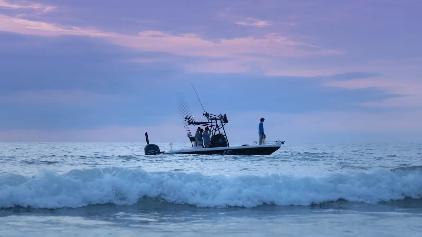 A small passenger boat under way on calm open water beneath a wide sky